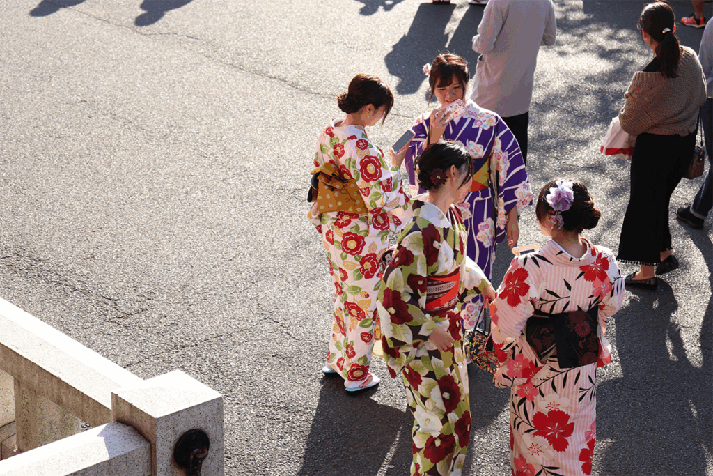 Women dressed in colorful yukata, savoring summer treats and the joyful energy of the festival.