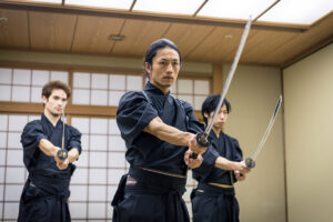 Japanese martial arts athlete training kendo in a dojo - Samaurai practicing in a gym