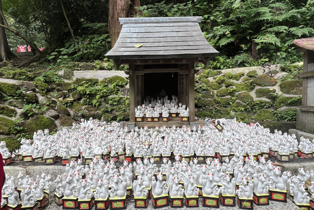 Small kitsune statues, known as fox spirits, guarding the shrine