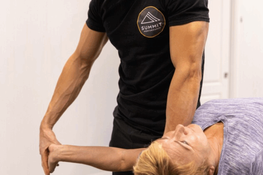 Personal trainer assisting a client with a stretching exercise to improve flexibility