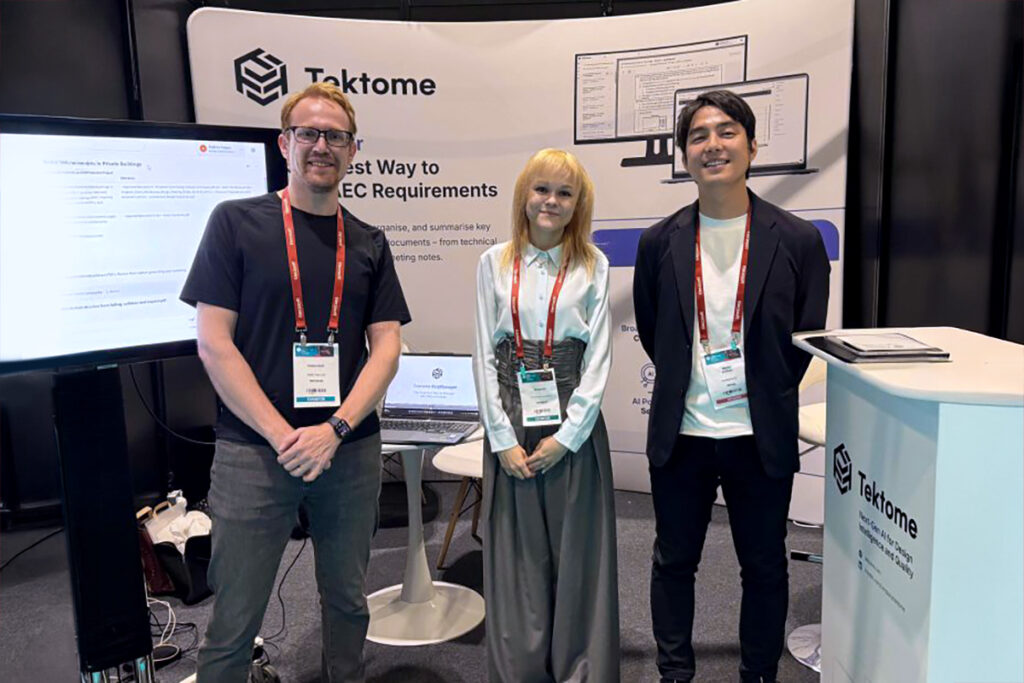 Tektome representatives standing in their booth