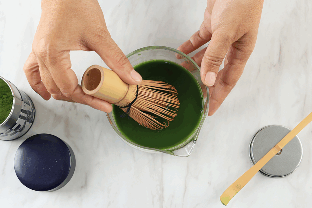 whisking matcha powder with traditional Japanese tools