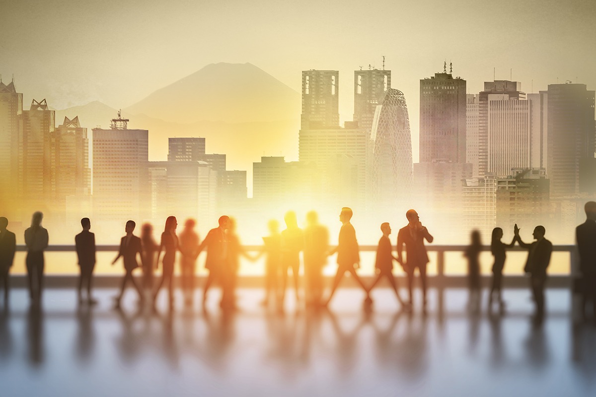 Silhouettes of people meeting with Tokyo skyline and Mount Fuji in the background at sunrise