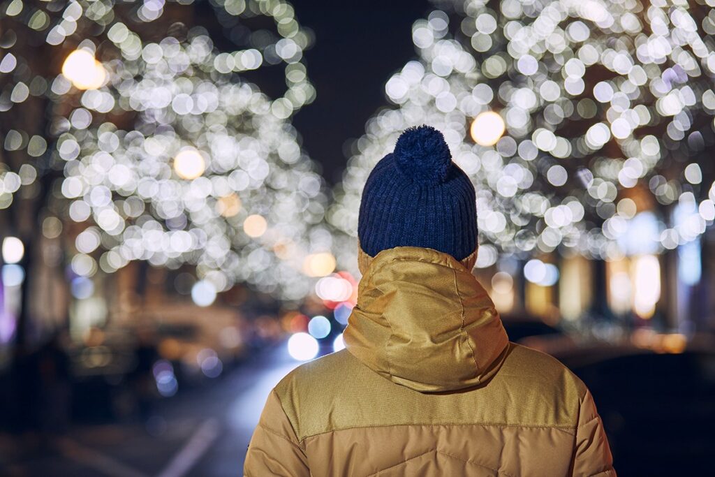 Person surrounded by holiday lights during Christmas season