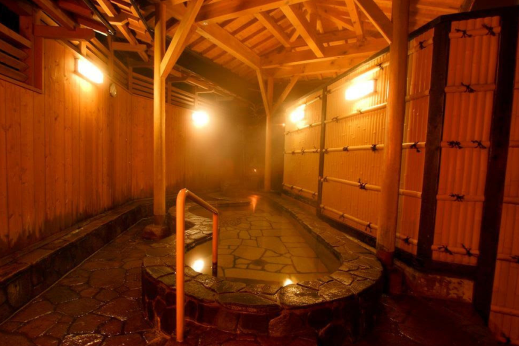 Private hot spring bath within a wooden structure at Kinosaki Onsen.