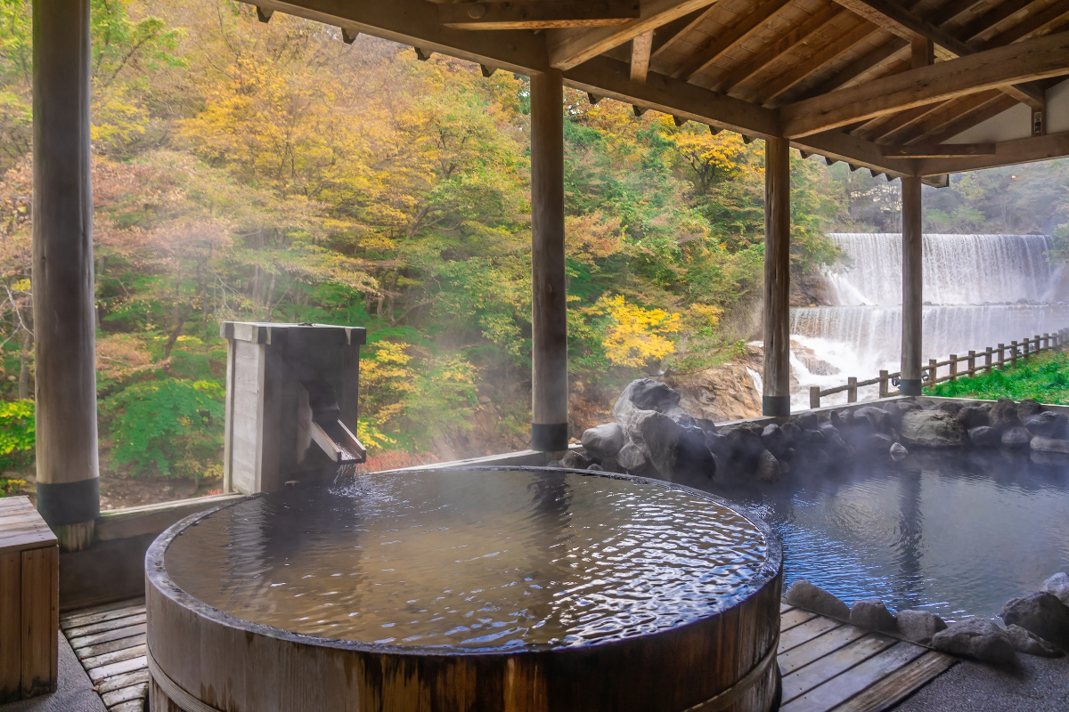 Outdoor onsen overlooking nature during autumn, reflecting the relaxing hot spring retreats near Tokyo.