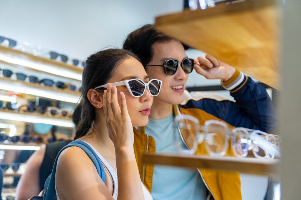 An asian couple modeling sunglasses at an eyewear store.