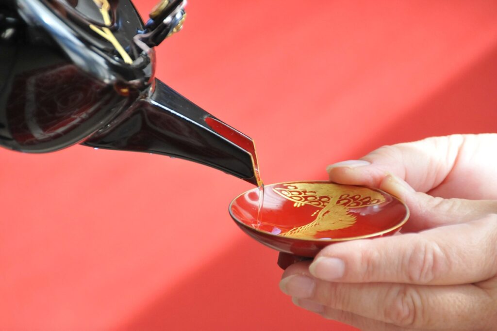 Japanese sake pouring into handcrafted lacquerware