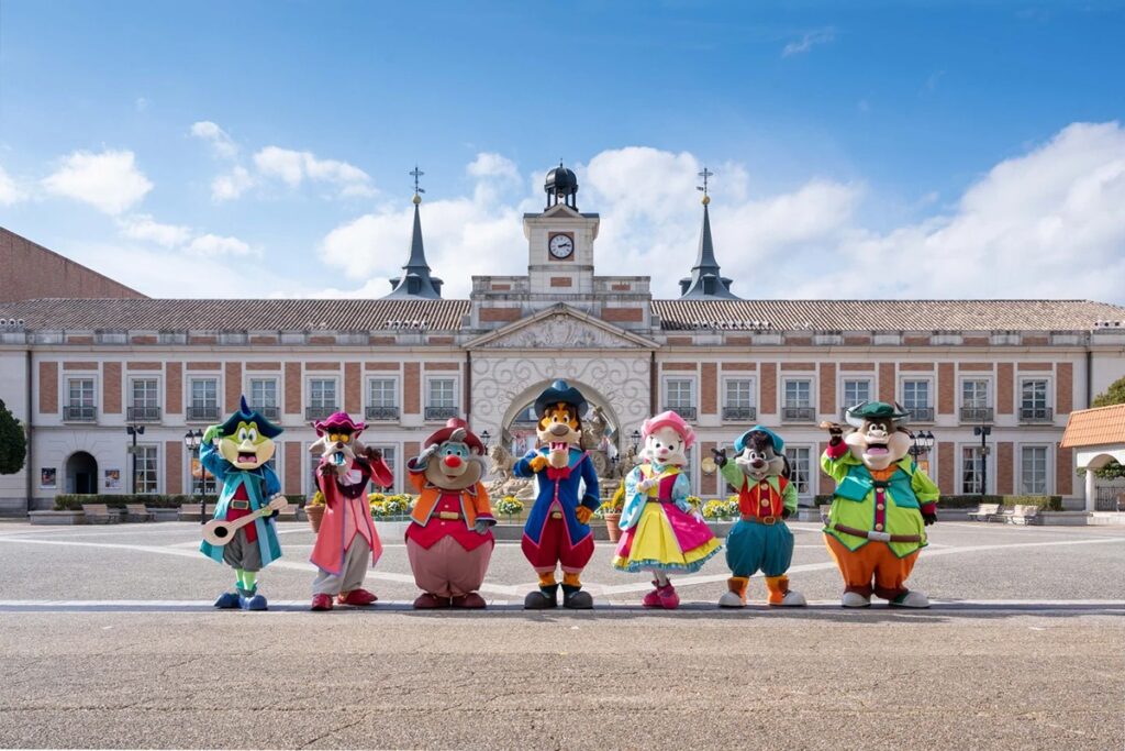 Shima Spain Mura mascots in front of a Spanish townscape