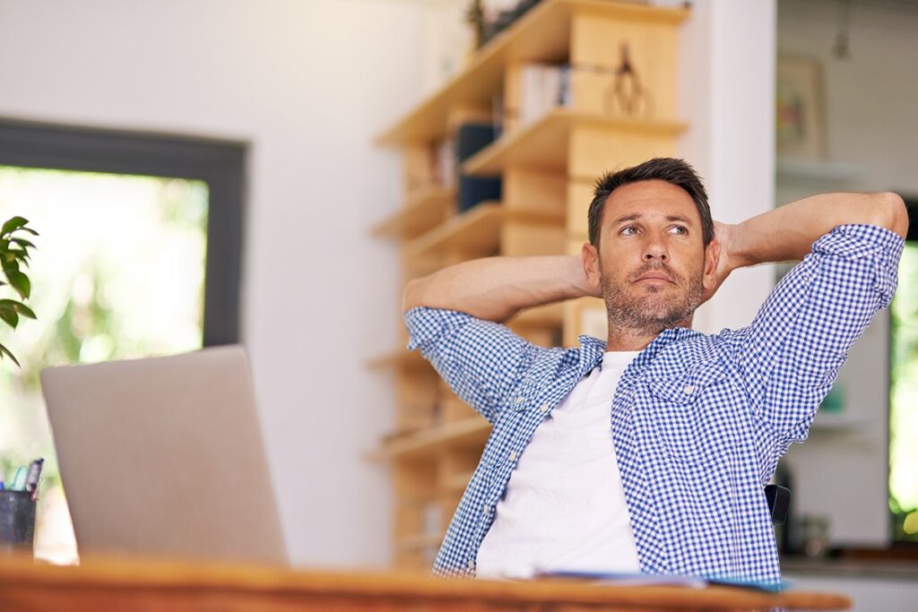 man on his computer stretching