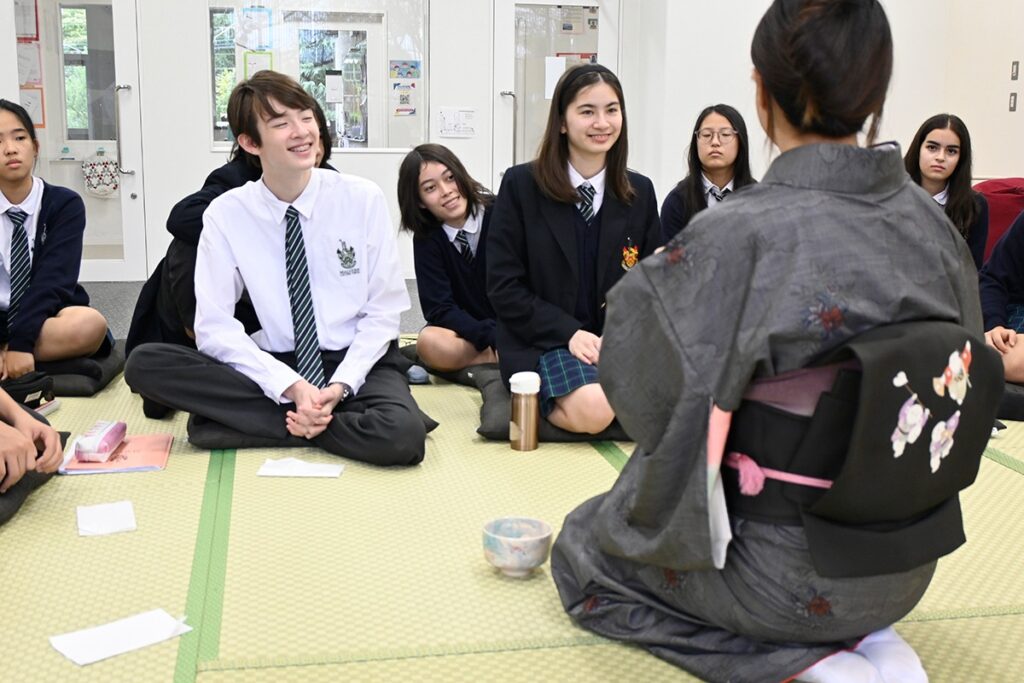 Teacher in kimono talking to Malvern College Tokyo students during a cultural activity