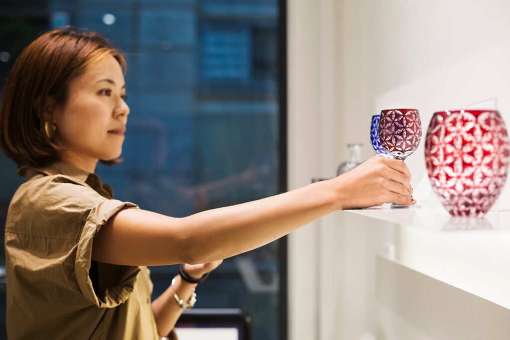 customer browsing kiriko and picking up a red glass