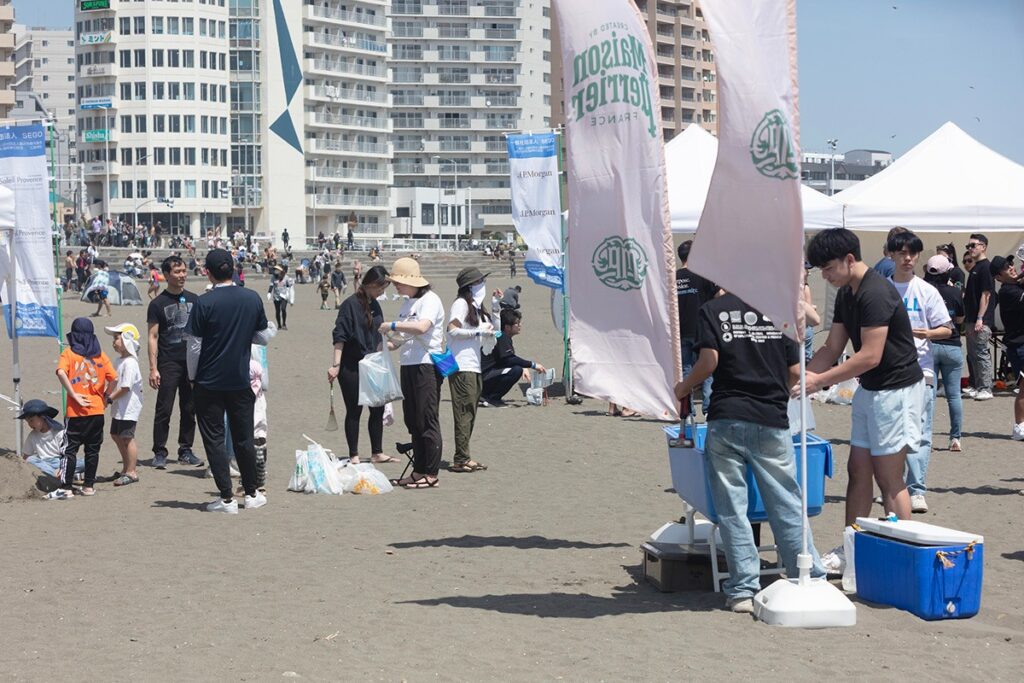 people on a beach working together to collect trash during a beach cleanup