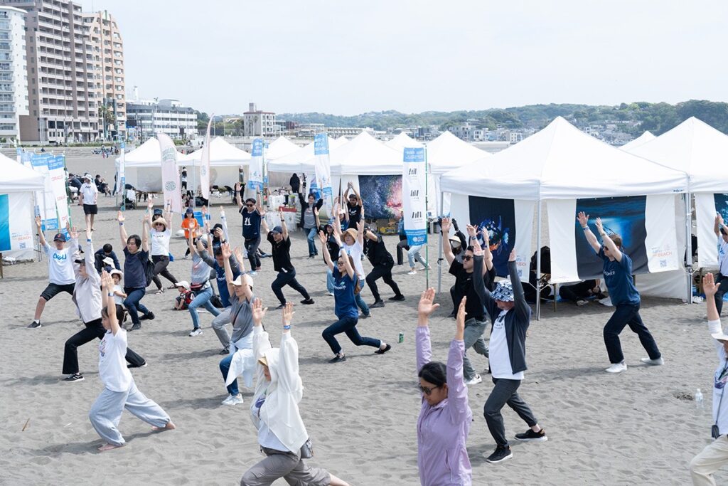 People on Japan a beach exercising during a SEGO Initiative beach cleanup event