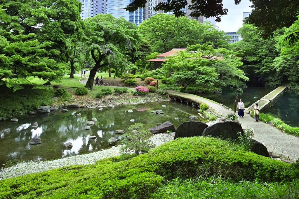 Two people walking by the lake in Koishikawa Koraku garden