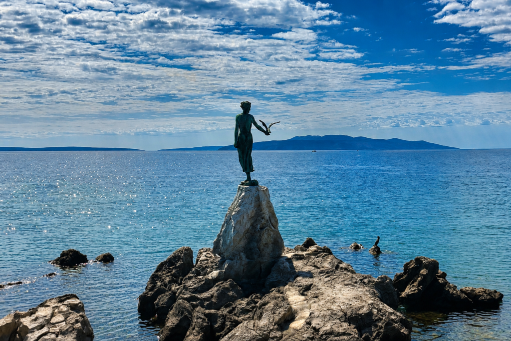 A human statue on a precipice out to sea, with a bird perched on its hand